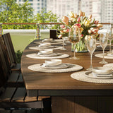 This is a up close view of the Antique Mahogany and Black colored dining table with matching chairs. There are plates and wine glasses on the table.