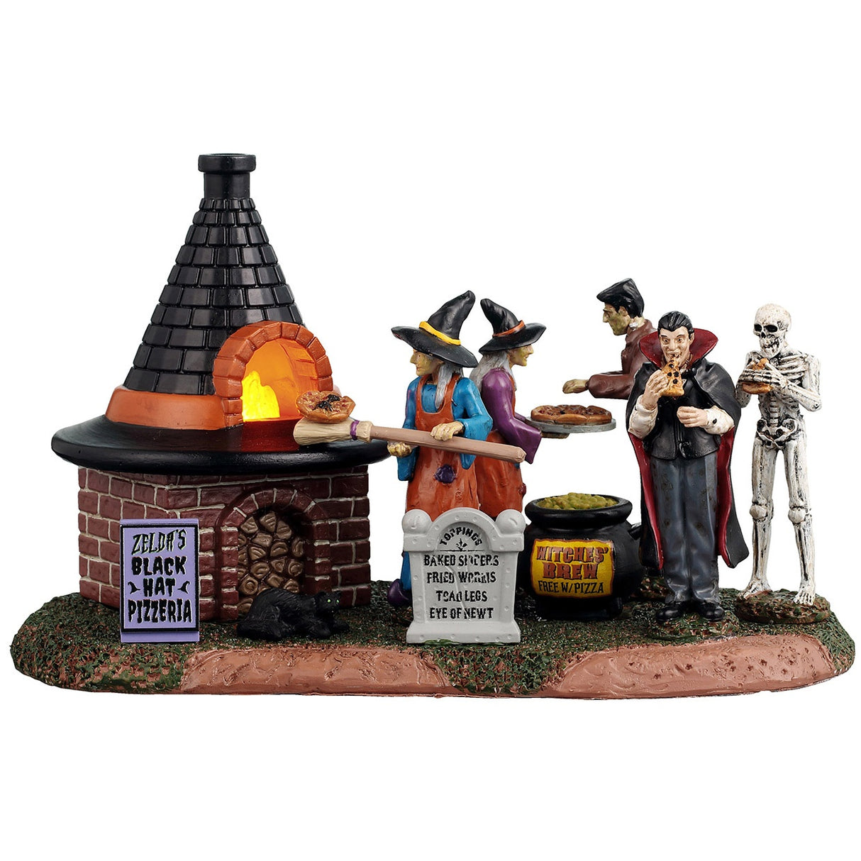 This image shows what this Lemax Spooky Town table accent looks like on a white background. It's designed to look like two witches using a wood fire oven to cook pizzas. There are two signs that read "Zelda's Black Hat Pizzeria" and "Toppings: Baked spiders, Fried Worms, Toad Legs, Eye of Newt." There's also a sign on the cauldron that reads "Witches' Brew Free with Pizza."