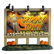 This image shows what this Lemax Spooky Town accessory looks like on a white background. It was designed to look like a big, lighted sign. It reads "Welcome to Spooky Town. We're dying to meet you." The sign is decorated with a skeleton wearing a top hat, bats, spiders, spiderwebs and a pumpkin. There's a crow resting on top of the sign and a line of skulls on the bottom of the sign. There are jack-o-lanterns on the ground underneath the sign.