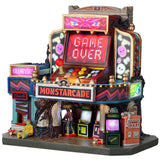 This image shows what this Lemax Spooky Town lighted building looks like on a white background. It was designed to look like an arcade made out of an arcade game cabinet. It has lots of bright graphics. There's a big sign that reads "GAME OVER." There are large buttons and a joystick over another sign that reads "MONSTARCADE."