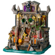 This image shows what this Lemax Spooky Town lighted building looks like on a white background. It was designed to look like a stone and brick cave shaped like a skull in some water. The front door is in the skull's mouth. There's a Grim Reaper standing up top. There are skulls and bones and fires and snakes.