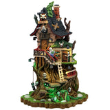 This image shows what this Lemax Spooky Town lighted building looks like on a white background. It was designed to look like a tall house built into a very large tree. There are skulls and bones everywhere, along with lots of ladders and stairs. There's a green snake near the base of the tree.