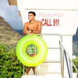 This is a lifestyle image showing a man standing on a lifeguard station holding the neon yellow inner tube.