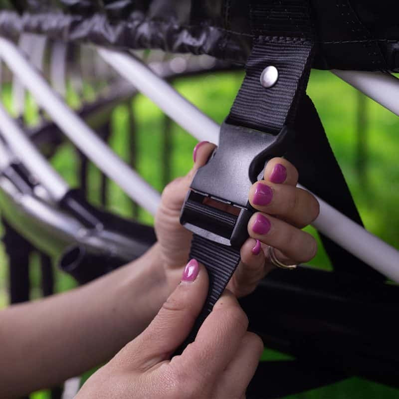 This is an up close view of someone buckling the trampoline cover into place.