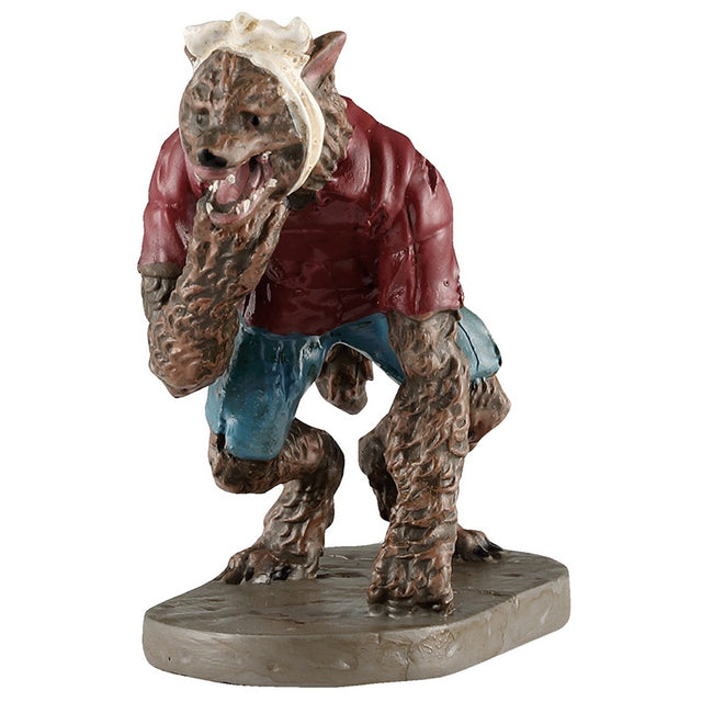 This image shows what this Lemax Spooky Town figurine looks like on a white background. It was designed to look like a werewolf wearing a maroon shirt and ripped blue jeans. He has a white towel wrapped around his head, indicating he has a toothache.