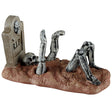 This image shows what this Lemax Spooky Town figurine looks like on a white background. It was designed to look like a skeleton clawing it's way out of the ground in front of a tombstone that reads "RIP."