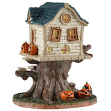 This image shows what this Lemax Spooky Town table accent looks like on a white background. It's designed to look like a pale yellow, semi-dilapidated tree house. It's decorated with jack-o-lanterns.