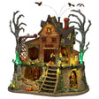 This image shows what this Lemax Sights and Sounds building looks like on a white background. It was designed to look like a dilapidated, wooden cabin with bare trees next to it. There are vultures circling above and monsters walking around. You can see the ground underneath the cabin. There's a skeleton in a cage, there are some tombstones and a creaky ladder.