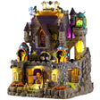 This image shows what this Lemax Spooky Town lighted building looks like on a white background. It was designed to look like a large, tall stone castle. There are monsters everywhere and jack-o-lanterns and lab equipment.