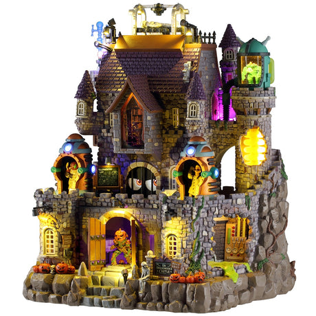 This image shows what this Lemax Spooky Town lighted building looks like on a white background. It was designed to look like a large, tall stone castle. There are monsters everywhere and jack-o-lanterns and lab equipment.