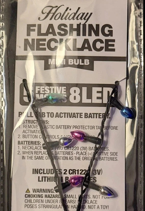 This image shows the back of this necklace's packaging. It reads "Holiday Flashing Necklace Mini Bulb. 5 Festive Modes. 8 LED lights. Pull tab to activate battery."