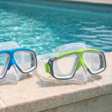 This is a lifestyle image showing two different pairs of goggles on the edge of a pool.