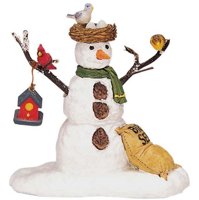 Polyresin figurine for a Lemax display. Designed to look like a snowman wearing a scarf. There's a nest with a bird and eggs in it on the snowman's head. There are birds on the snowman's twig arms and a birdhouse hanging from the left one. The buttons on the snowman are made of acorns. There's a bag of bird seed lying on the ground next to the snowman.