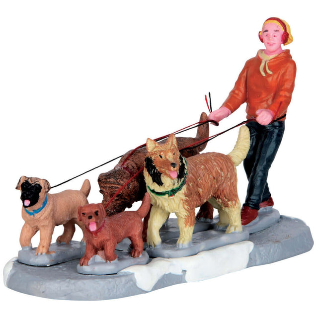 Village accent for a Lemax display. Designed to look like a young person walking a pack of dogs in the snow.