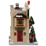 This image shows what the side of this building looks like. There's a red door with a sign on each side. On the left side of the door, there's a red sign that reads "Rock Bottom Prices, Roll on Down!" On the right side of the door, there's a green sign that reads "All Holiday Records are On Sale Now!" Above the door, there's a red and green sign that reads "Rockin' Hoppin' Records Bargain Basement."