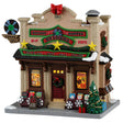 This image shows what this Lemax building looks like on a white background. It was designed to look like a tall record shop. There's a red bow and fake film reel being used as decorations on the roof. The roofline is decorated with garlands, wreaths and gold stars. Near the front door, there are wooden containers of Christmas vinyl and albums. There's a sign above the front door that reads "LPs & 45s, Buy, Sell, Trade."