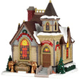 This image shows what this Lemax building looks like on a white background. It was designed to look like a large church. There are lots of windows with stained glass, golden angels near the front door and lots of red ribbon and wreaths.