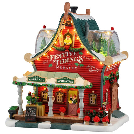 This image shows what this Lemax Santa's Wonderland lighted building looks like on a white background. It was designed to look like a red house turned into the Festive Tidings Nursery. On the porch, there's a table with elf made wreaths for sale. On the side of the house, there's an elf decorating wreaths. There are two dome windows on the roof where you can see some trees inside.