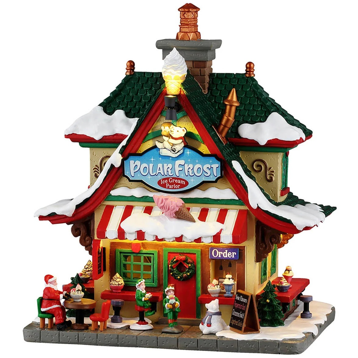 This image shows what this Lemax building looks like on a white background. It was designed to look like a tall house that was turned into an ice cream parlor. The roofs and sidewalk are covered in snow. Santa is eating at one of the tables on the sidewalk and there are elves looking at the menu before ordering at the window.