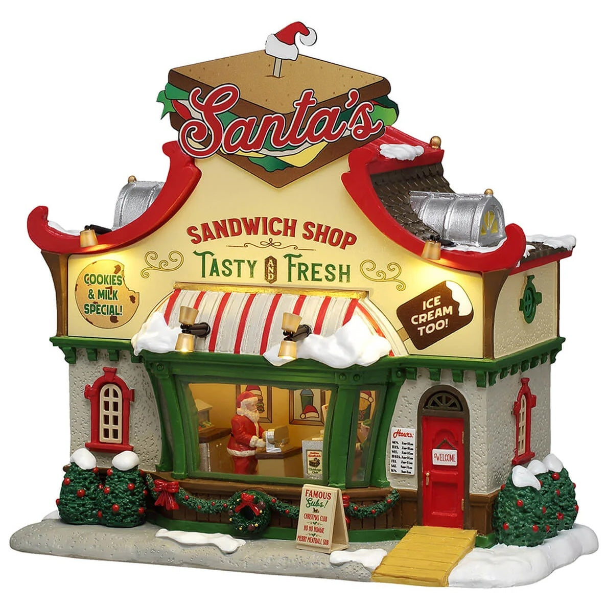 This image shows what this Lemax building looks like on a white background. It was designed to look like a restaurant. On the roof, there's a large, decorative, fake sandwich with a pick in it. The pick has a Santa's hat on it. There's a large window in the front where you can see the inside. Santa is picking up his food from the counter inside. There's snow on the roof and on the sidewalk.