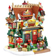 This image shows what this Lemax building looks like on a white background. It was designed to look like a uniquely decorated, tall restaurant. There's a sign on the roof that reads "The Best Eggnog in the Arctic!" There are elves sitting around, from the roof to the front stairs. There's snow on the roof and the sidewalk. There are lots of little signs everywhere.