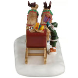 This image shows what the table piece looks like from the back. The sled is full of presents and there's an elf on the right side loading more presents into it. The two reindeer are wearing wreaths around their necks.