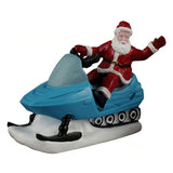 This image shows Santa on a blue snowmobile. He's wearing his classic red and white suit and waving.