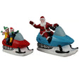 This image shows what these two Lemax Santa's Wonderland figurines look like on a white background. It's designed to look like Santa and some elves driving snowmobiles. 