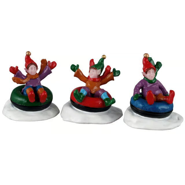 This image shows what these three figurines look like on a white background. The scene was designed to look like three elves riding snow tubes in the snow.