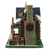 This image shows what the other side of this building looks like. The stone chimney is decorated with a large wreath. There's also a sled leaning against the chimney.