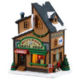 This image shows what this Lemax building looks like on a white background. It was designed to look like a tall skate shop. There's a window near the front door where there's a person ready to give you skates in your size. There are signs that read "Wally's Winter Skate Shop," "Skating Season is Here!," "Rent or Buy!," "Equipment Rentals" and "Rink is Open!"