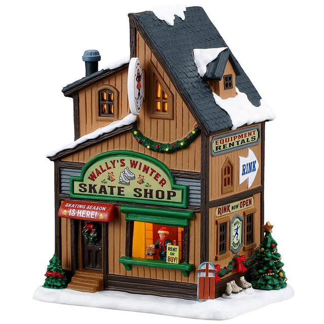 This image shows what this Lemax building looks like on a white background. It was designed to look like a tall skate shop. There's a window near the front door where there's a person ready to give you skates in your size. There are signs that read "Wally's Winter Skate Shop," "Skating Season is Here!," "Rent or Buy!," "Equipment Rentals" and "Rink is Open!"