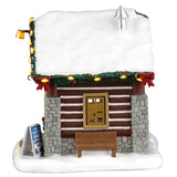 This image shows what one of the sides of this building looks like. The roof is covered in snow and there's a silver chimney. There's a small wooden bench underneath the side window.
