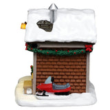 This image shows what the side of the house looks like. You can see the green garland with red bows along the roofline and the red snowmobile parked along the house.