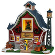 This image shows what this Lemax building looks like on a white background. It was designed to look like a red farmhouse that's been decorated for Christmas. There are wreaths and garlands and poinsettias all over. There's a large window in the center of the house and you can see a decorated Christmas tree. Farmer Judd is standing near the front door and there's a cute dog standing next to a few pumpkins.