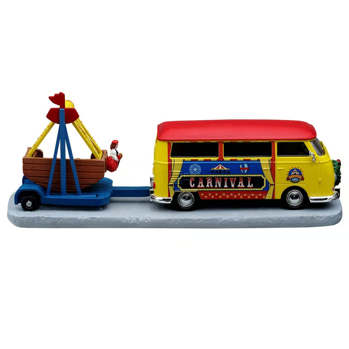 This image shows the other side of the Lemax item. The van is yellow with a red roof. It reads "Carnival" on the side and has small pictures of a Ferris Wheel, a merry-go-round and a hot air balloon. The carnival ride it is pulling behind it looks like a boat.