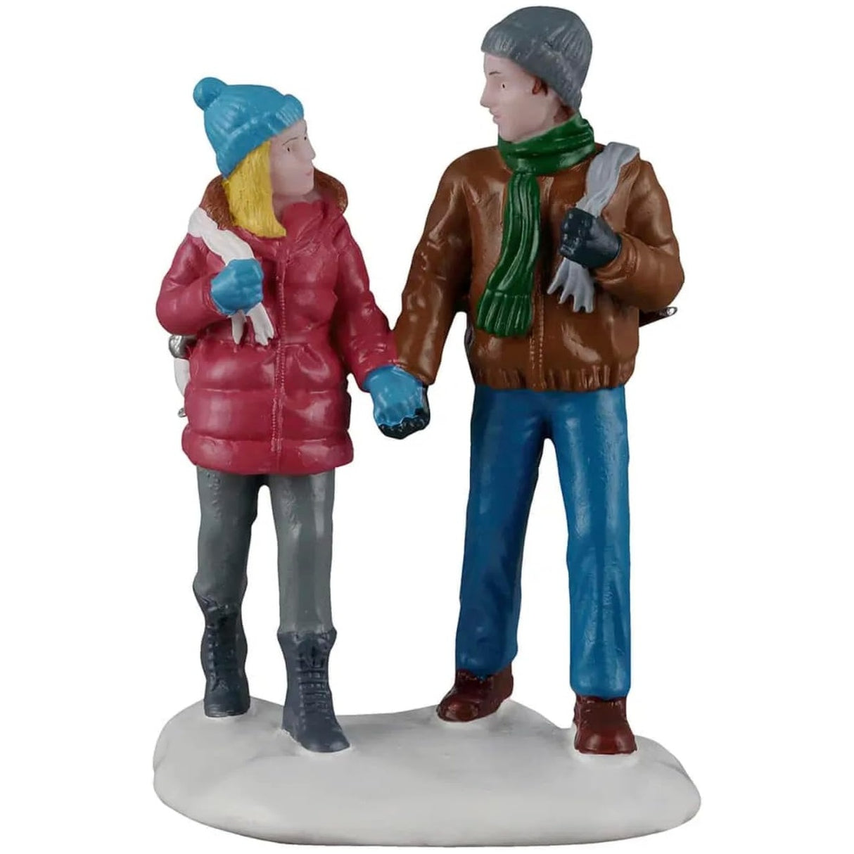 This image shows what this Lemax Vail Village figurine looks like on a white background. It was designed to look like two people holding hands, walking through snow. The woman is wearing a light blue knit hat, a maroon jacket, light blue gloves, grey pants and dark grey boots. The man is wearing a gray knit hat, a green scarf, a brown jacket, blue jeans and brown shoes. They're both holding a pair of ice skates over their shoulders.