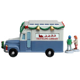 This image shows the other side of the van. It reads "Traveling Library" and has an image of Santa's sleigh with reindeer. The top of the van is white and the bottom of the van is blue.