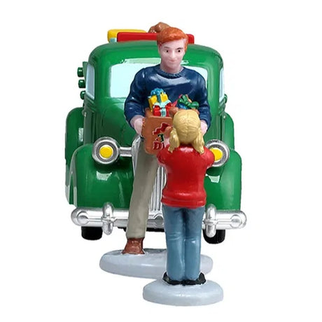 This is a front facing view of these particular figures. We see the back of the little girl. She's wearing a red sweater and blue jeans. She has blonde hair set in two pigtails.