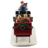 This image shows what this table accent looks like from the back. There's a decorated garland and wreath on the back of the sleigh. The man in the couple has blonde hair and is wearing a brown jacket, a tan shirt, grey pants and brown shoes.