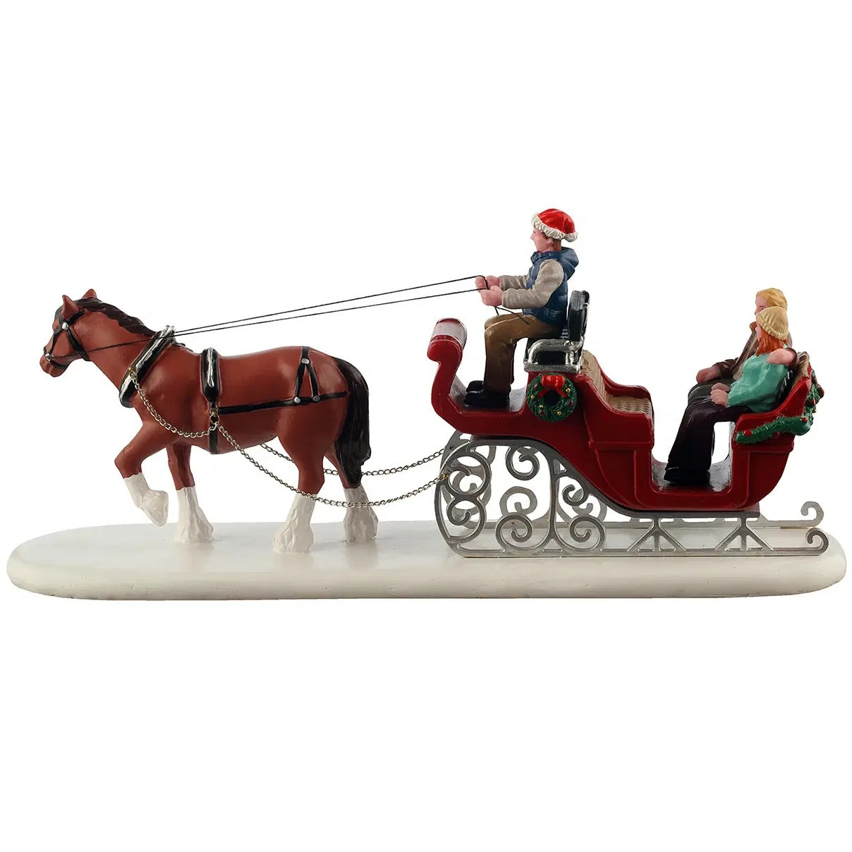 This image shows what this table accent looks like from the side. The horse is brown with black and gold reins. There's a wreath on the side of the sleigh. There's a couple in the back of the sleigh. The woman has orange hair and is wearing a tan colored hat, along with a teal jacket and black pants.