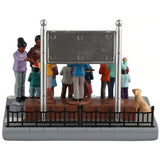 This image shows what this table piece looks like from the back. The sign behind them is silver on the back. There's also a small golden retriever dog watching from the side.