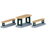 This image shows what these Lemax Village accessories look like on a white background. It was designed to look like a table with two benches. The top of the table and the benches are a light brown color and the bottoms are a dark green.