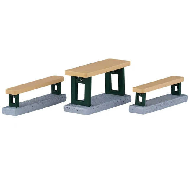 This image shows what these Lemax Village accessories look like on a white background. It was designed to look like a table with two benches. The top of the table and the benches are a light brown color and the bottoms are a dark green.