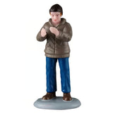 This figurine was designed to look like a man clapping. He's wearing a black hat, a light brown jacket, blue jeans and brown shoes.