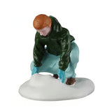 This figurine was designed to look like a boy bending down to gather snow to create a snowball. He's wearing a forest green jacket, blue jeans and brown shoes.