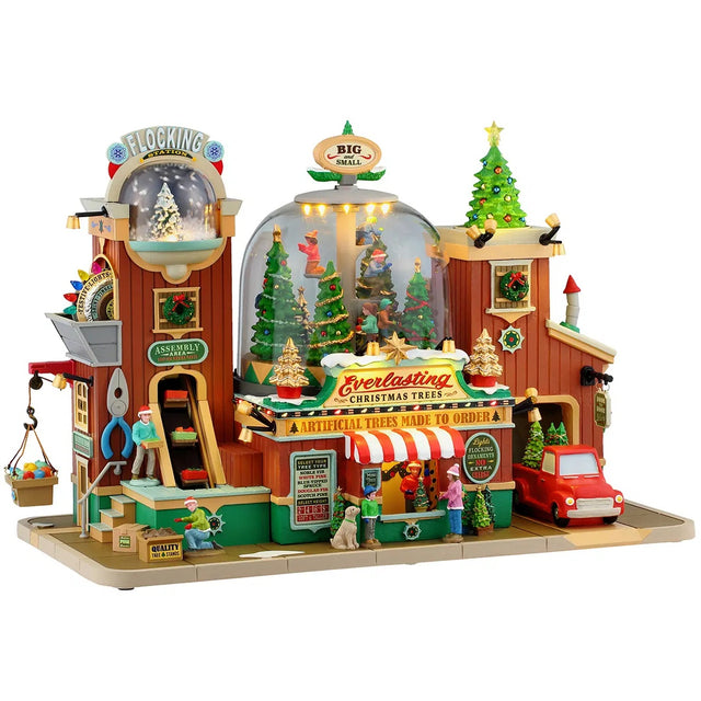 This image shows what this Lemax Caddington Village Sights and Sounds building looks like on a white background. It was designed to look like a Christmas tree shop. It's decorated with trees of all sizes. There are people working and people shopping. The side of the building has a giant string of lights and inside the building, there's a globe full of people decorating trees. There's also another smaller globe on the left side where trees go to get their branches flocked.