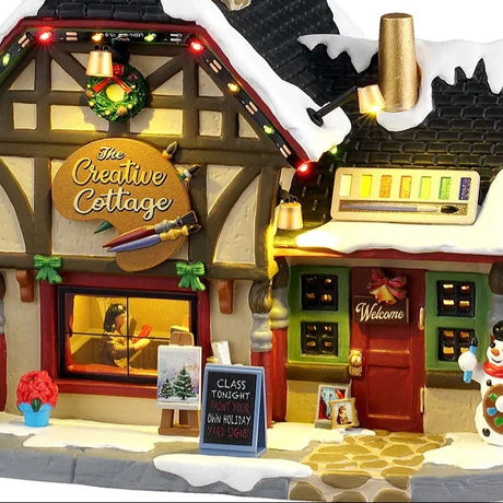 This is an up close view of this lighted building. There's a sign near the front door that reads "Class Tonight! Paint Your Own Holiday Yard Signs!"