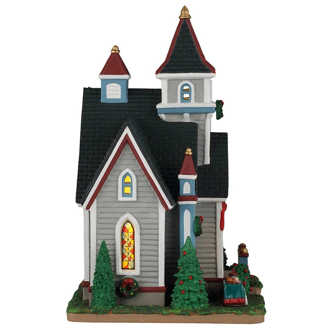 This image shows what the other side of this building looks like. There's a stained glass window and decorated trees. There's also a table with baked goods on it for the bake sale.