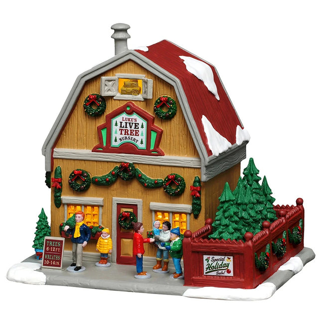 This image shows what this Lemax building looks like on a white background. It was designed to look like a yellow barn that sells live trees. The roof and the sidewalk are covered in snow. There are garlands, wreaths and red bows everywhere. There are people standing near the front door. Off to the right, there's a red fenced in area with a bunch of trees.